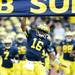 Michigan senior quarterback Denard Robinson reaches for the banner as the team runs onto the field at Michigan Stadium on Saturday. Melanie Maxwell I AnnArbor.com
